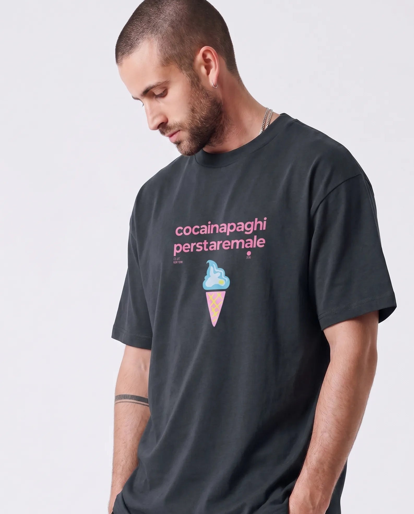 T-shirt oversize streetwear uomo nera con scritta rosa bubble "cocainapaghiperstaremale" e grafica gelato centrale a cono,.