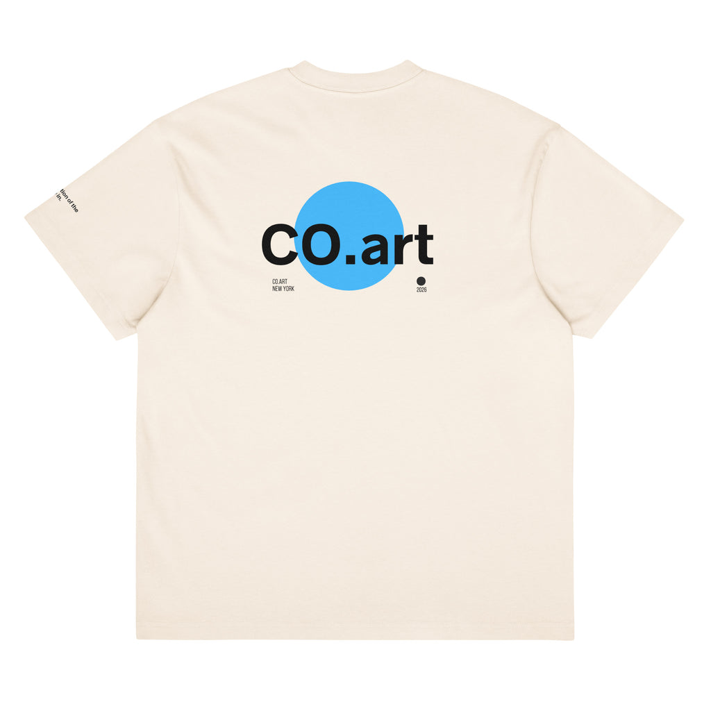T-shirt oversize bianca con grafica streetwear sul retro, scritta nera "co.art" su cerchio blu, stile manifesto con.