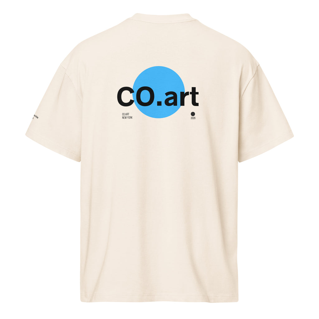 T-shirt oversize bianca con grafica streetwear sul retro, scritta "co.art" nera su cerchio blu, stile manifesto messaggio.