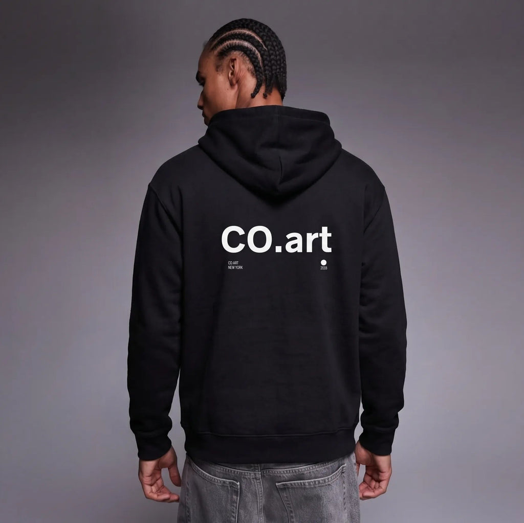 Felpa nera oversize unisex con cappuccio, grafica bianca "CO.art" sul retro, stile streetwear con messaggio forte e design.