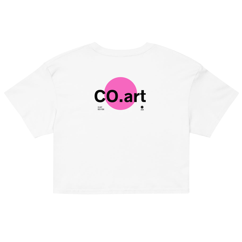 Crop top bianco in cotone con grafica streetwear e testo "co.art" nero su cerchio rosa, stile manifesto messaggio forte.